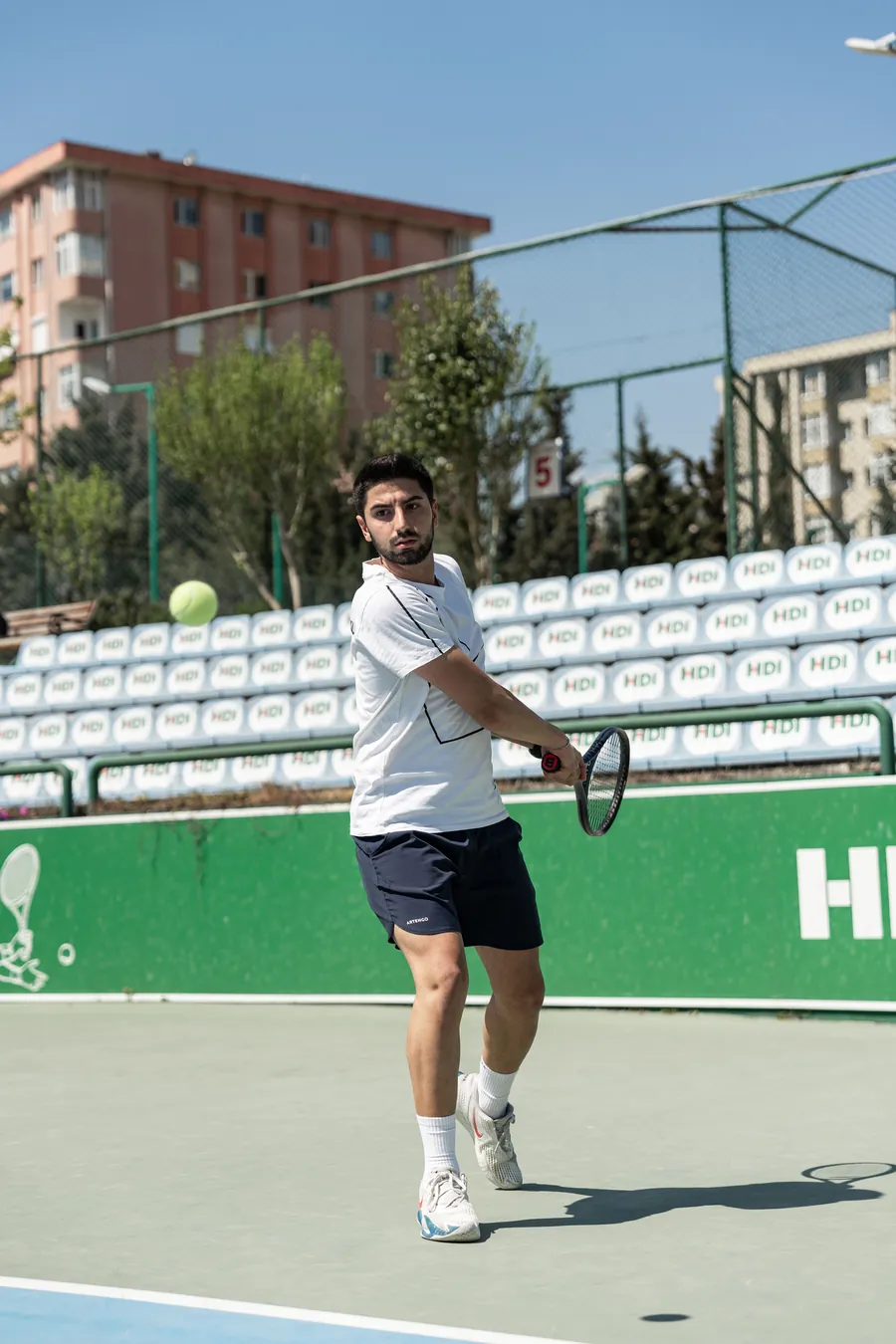 Player turning the shoulders on a backhand, a movement coaches shorten for padel