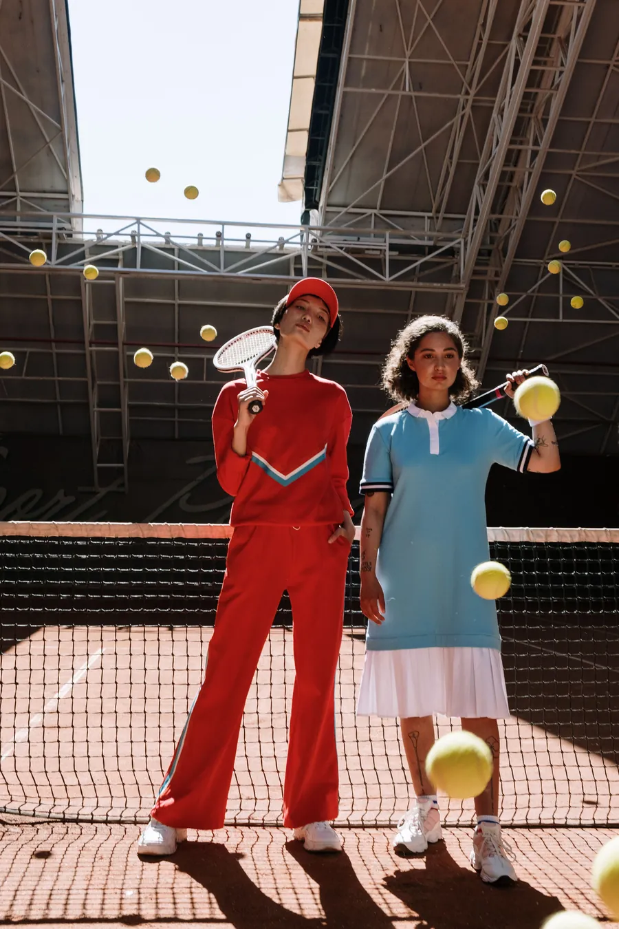 Two players holding tennis rackets by the net on a covered clay court
